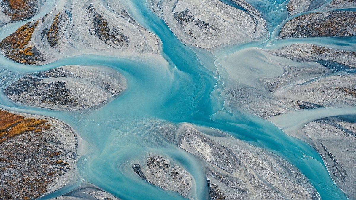 QUIQQER 2.25 – Turquoise river delta Aerial view of a turquoise glacial river delta between pale mineral islands